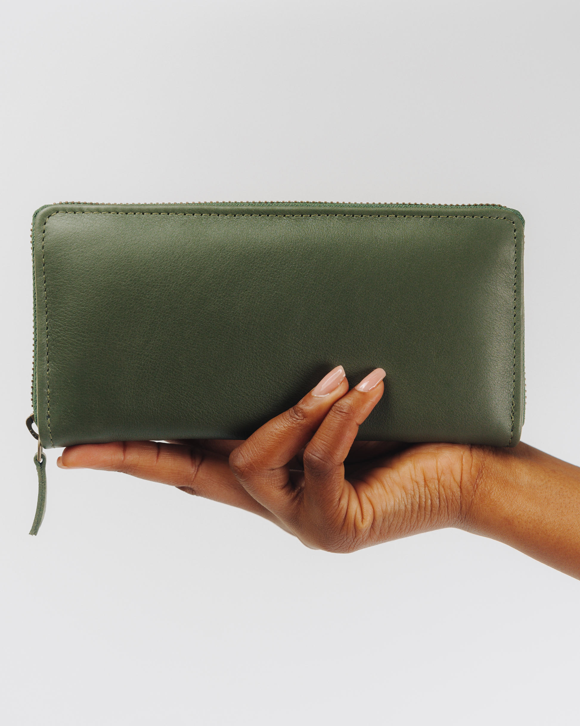 Green Essential zip wallet in hand for scale