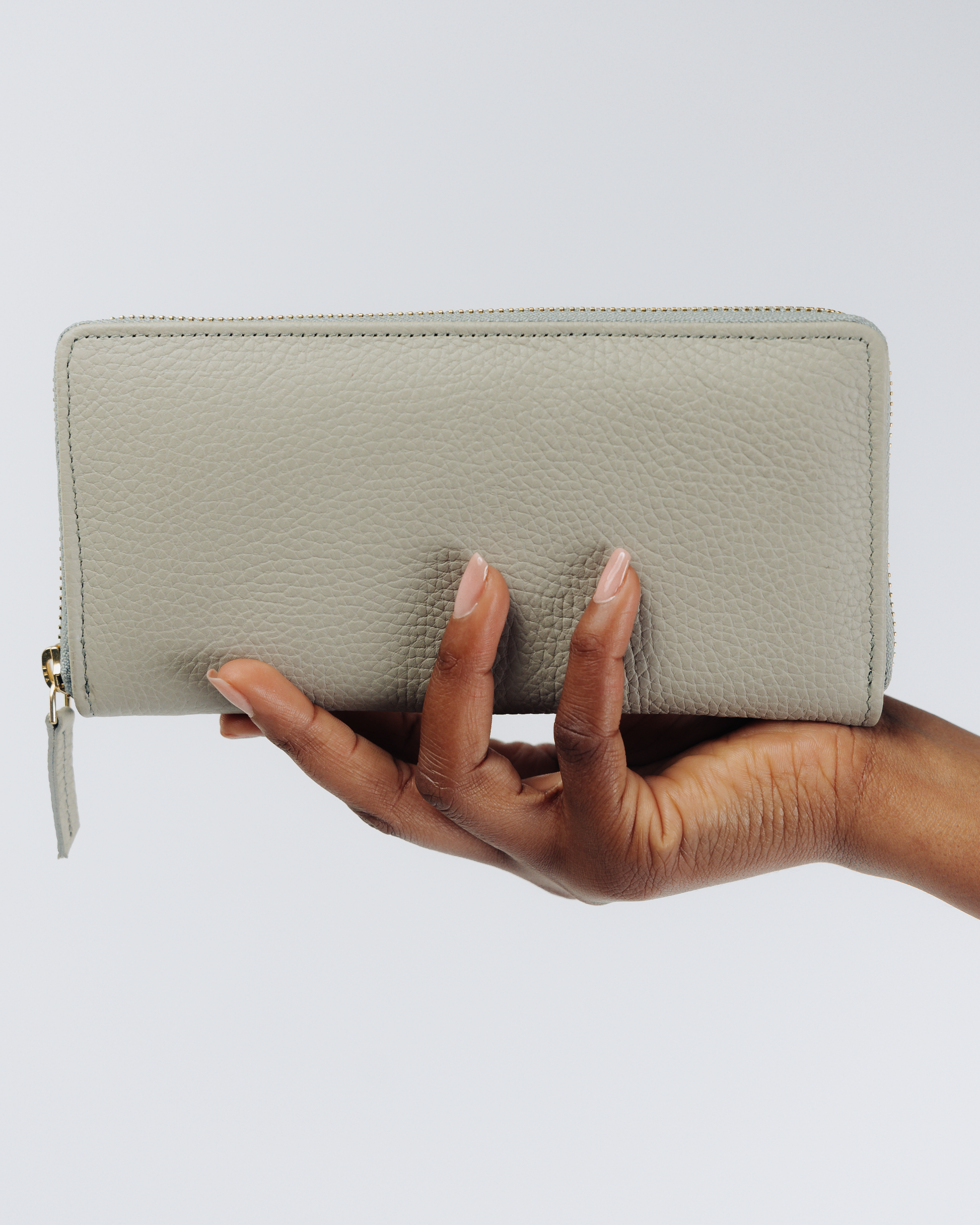 Grey Essential zip wallet in hand for scale
