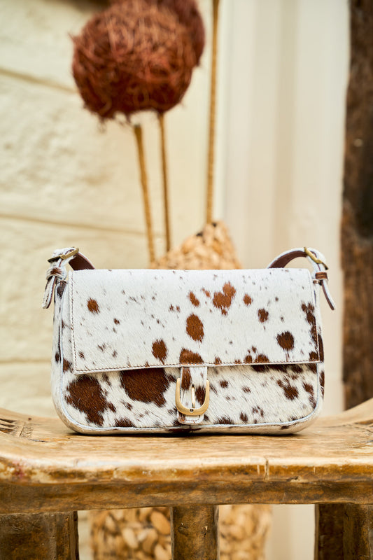 Manda cowhide mini handbag with hair-on-hide pattern, front view with brass buckle detail