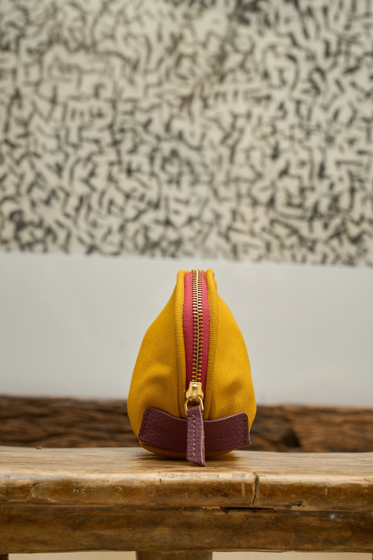 Yellow pouch with a contrasting zipper and leather zipper pull.