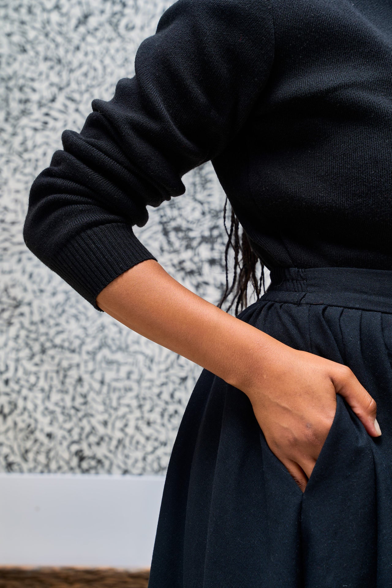 Woman wearing a black Shani crew neck textured wall background