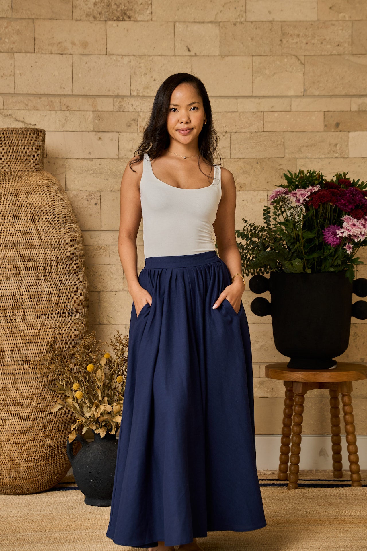 A navy midi skirt made of linen blend, designed with pockets, pleats, and an elastic waistband for comfort.