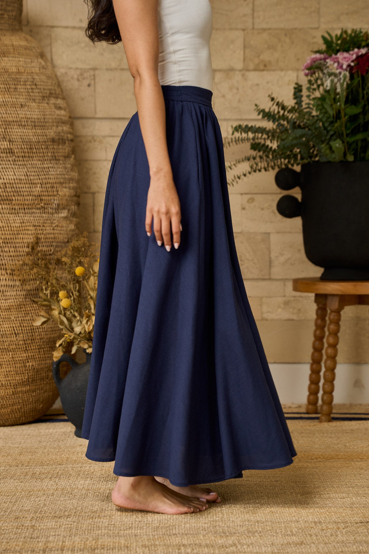 A navy midi skirt made of linen blend, designed with pockets, pleats, and an elastic waistband for comfort.