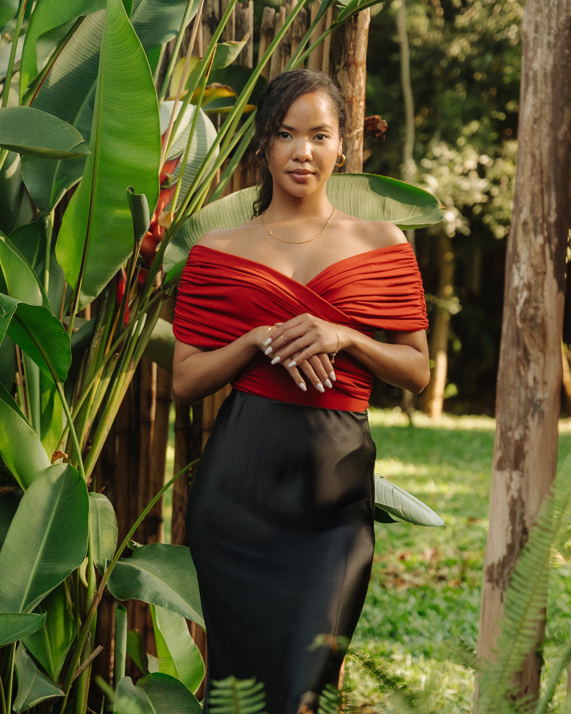 Red Ruched bodysuit worn on model in a garden setting.