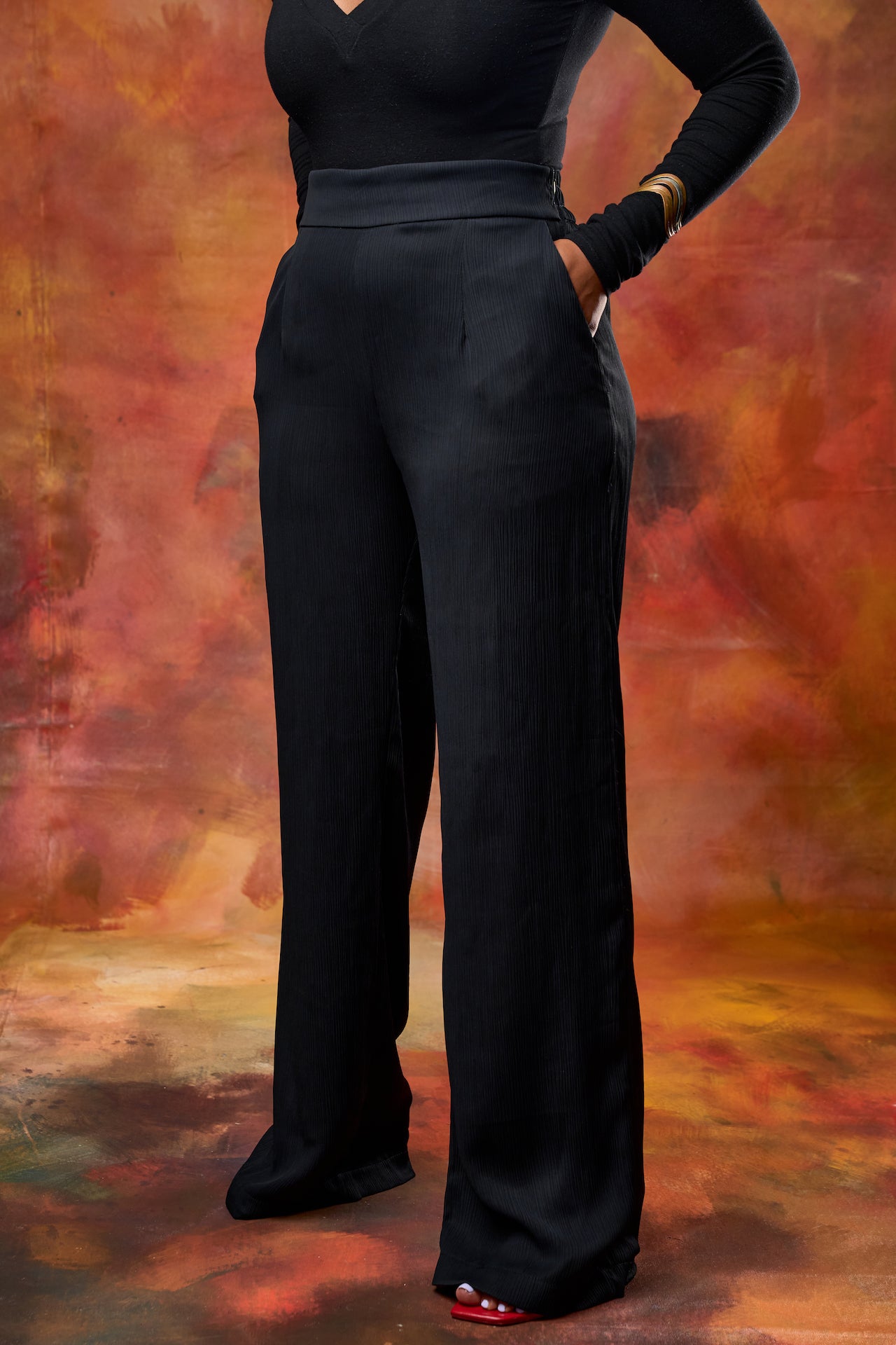 Woman wearing black high waisted wide leg  pants against with pockets from This is essential kenya.