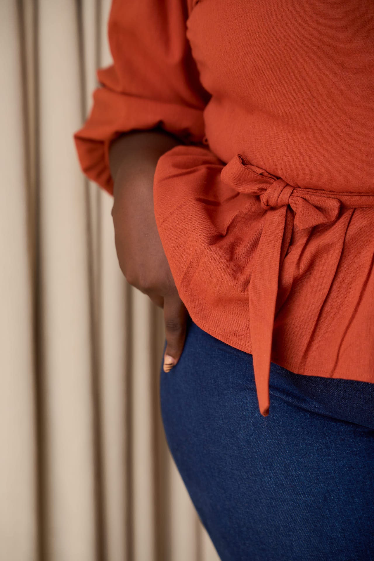 Side tie detail of Yana Linen blend burnt orange tope.