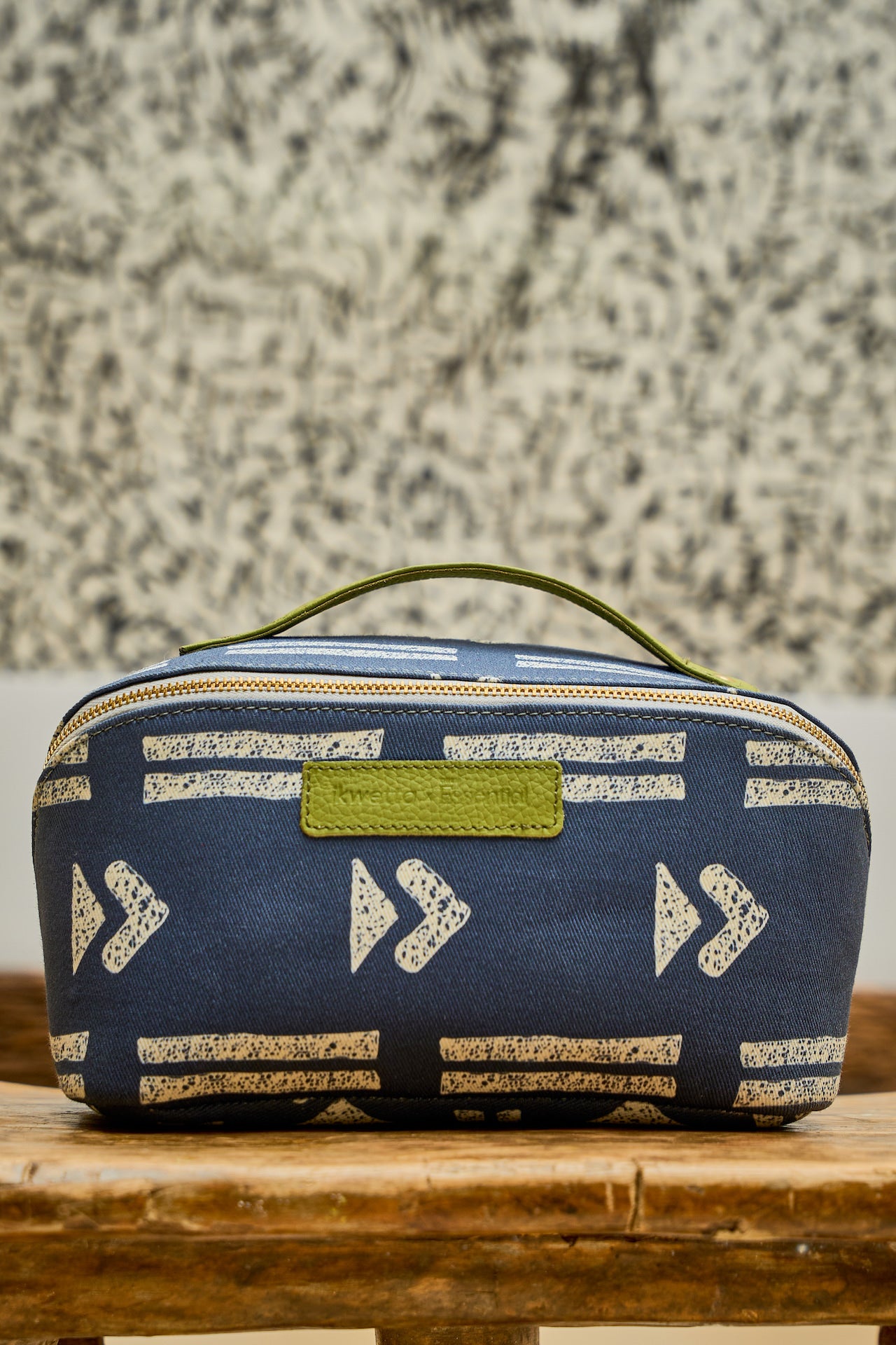  Blue Zola toiletry bag in mudcloth print, with a green leather handle.