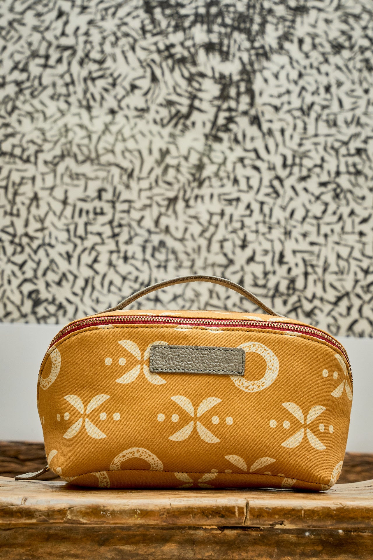 Yellow cosmetic bag with white patterns on a textured surface